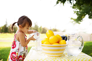 Girl pouring water at picnic table